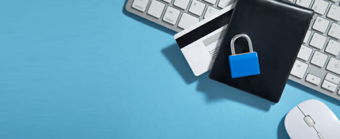 padlock over wallet and credit card on top of keyboard, representing business finances protection with segregation of duties controls