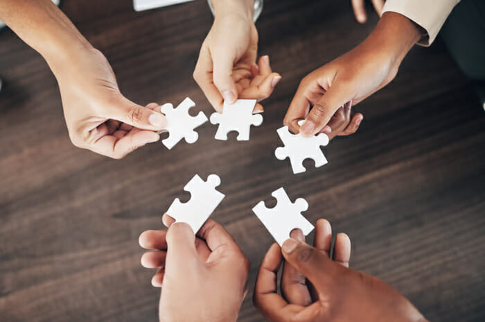 employees holding puzzles pieces representing segregation of duties